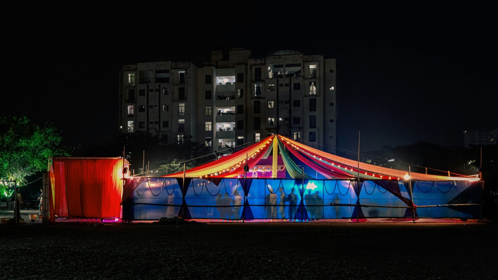 a circus tent is lit up at night